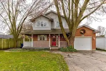 View of front of property featuring covered porch, a garage, and a front yard